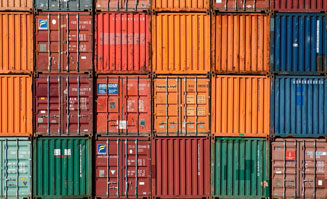 Das Foto zeigt eine geometrische Aufstapelung von verschiedenfarbigen Containern.
